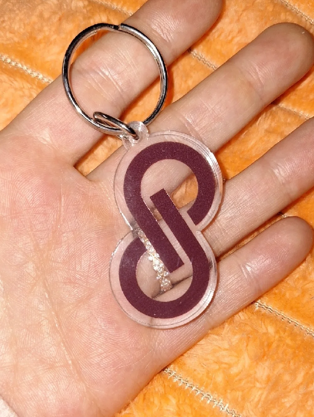 Clear acrylic keychain featuring a bold purple interlocking Poshmark logo.
